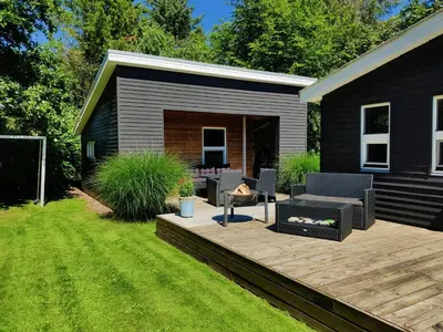 a backyard with a deck with chairs and a grill at Home Near Beach With Wilderness Bath in Sindrup