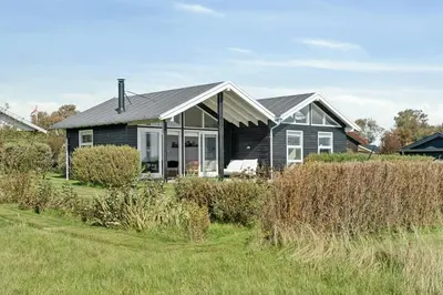 a black house with a gray roof at Cozy Home By Limfjord With Bathing Jetty in Snedsted