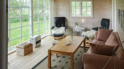 a living room with a cow statue in the middle at Charming Wooden Cottage Close To Handbjerg Beach in Vinderup