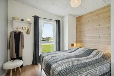 a bedroom with a large bed and a window at Modern Light House With Terrace Near The Fjord in Løgstrup