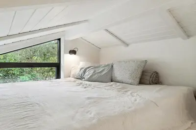 a white bedroom with a bed and a window at Cottage At Feggeklit With Limfjord Views in Nykøbing Mors