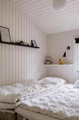 a white bed in a room with a wall at Bright And Lovely Summerhouse In Løkken in Løkken