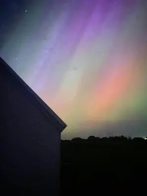 a rainbow colored sky with a building in the foreground at Renovated Farmhouse In Architectural Style in Lemvig