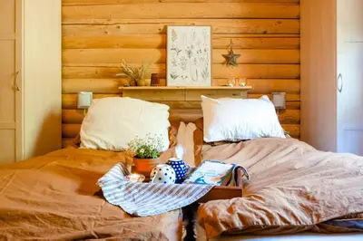 two twin beds in a room with wooden walls at Authentic Log House Amid Evergreens In Vendsyssel in Fjerritslev