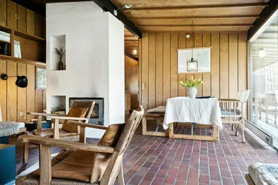 a dining room with a table and chairs and a fireplace at Authentic Friis & Moltke House In Lundo's Nature in Højslev