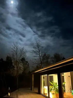 a house lit up at night with the moon at Summer House At Thyholm With Fjord View in Thyholm