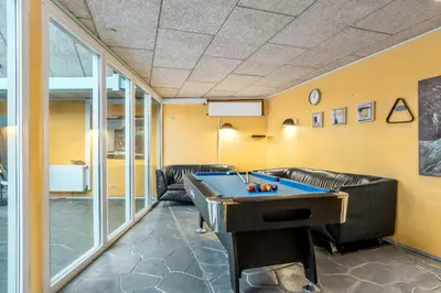 a gaming room with a pool table and leather furniture at Large Holiday Home With Pool And Spa In The Middle Of Blokhus Town, Close To The North Sea in Blokhus