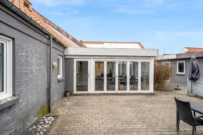 an extension to a house with sliding glass doors at Large Holiday Home With Pool And Spa In The Middle Of Blokhus Town, Close To The North Sea in Blokhus
