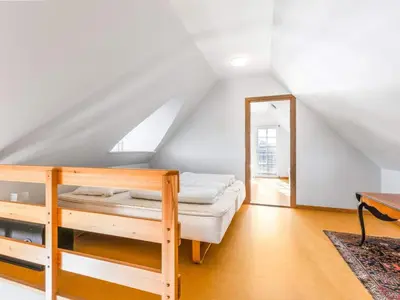 a attic room with a bunk bed and a mirror at Cozy Family Retreat - By Traum Ferienwohnungen in Blokhus