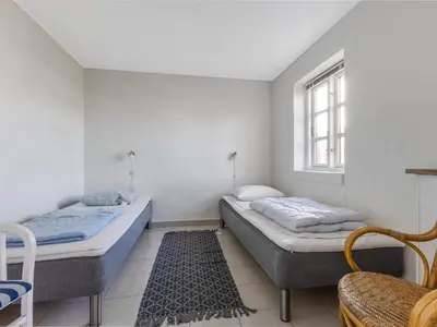 two beds in a room with a window and a rug at Cozy Family Retreat - By Traum Ferienwohnungen in Blokhus