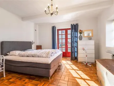 a bedroom with a bed and a red door at Charming Retreat in Blokhus - By Traum Ferienwohnungen in Blokhus