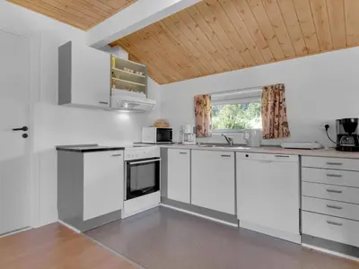 a kitchen with white appliances and a wooden ceiling at Green Oasis near Blokhus - By Traum Ferienwohnungen in Blokhus