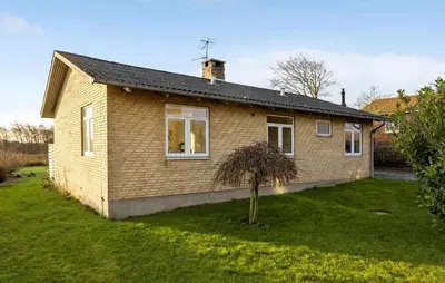 a small brick house with a small tree in the yard at 2 Bedroom Nice Home In Roslev in Roslev