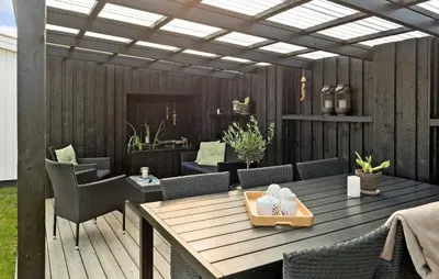 a patio with a wooden table and chairs at 4 Bedroom Awesome Home In Thisted in Thisted