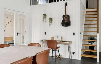 a dining room with a table and a guitar on the wall at Stunning Home In Spøttrup With Sauna in Spottrup