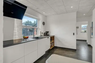 a kitchen with white cabinets and a large window at Lovely Holiday Home, Renovated In 2024, Located In Hanstholm By The North Sea in Hanstholm