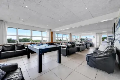 a living room with couches and a ping pong table at 40-Person Holiday Home, With Large Pool Area And Panoramic Views Of The Limfjord in Thyholm