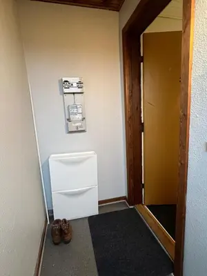 a small white refrigerator in a room with shoes at Perfect space for you and your colleague in Vinderup