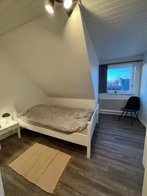 a small bedroom with a bed and a window at Perfect space for you and your colleague in Vinderup