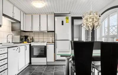 a kitchen with white cabinets and a table with a chandelier at Awesome Home In Øster Assels With Wifi in Øster Assels