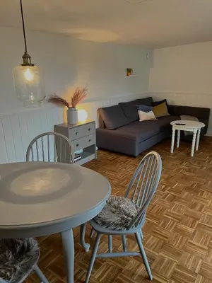 a living room with a table and chairs and a couch at Gæstehuset Husly in Haderup