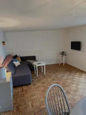 a living room with a couch and a table at Gæstehuset Husly in Haderup