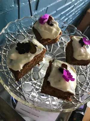 a plate of brownies with icing and flowers on it at Hostel Agger Vandrerhjem in Agger