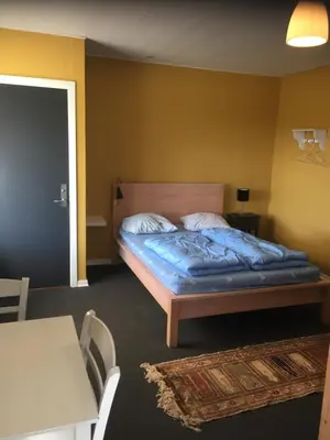 a bedroom with a bed with a blue comforter at Hostel Agger Vandrerhjem in Agger