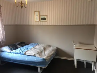 a small bed in a room with a desk at Hostel Agger Vandrerhjem in Agger