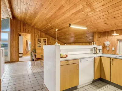 a kitchen with wooden walls and a wooden ceiling at Holiday Home Annemone - 600m from the sea by Interhome in Torsted