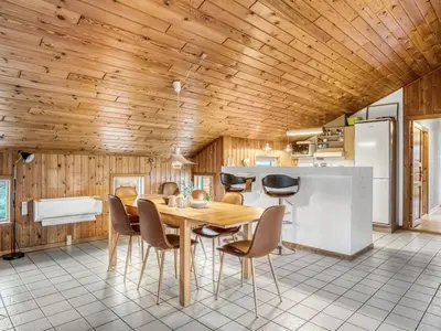 a kitchen with a wooden ceiling and a table and chairs at Holiday Home Annemone - 600m from the sea by Interhome in Torsted