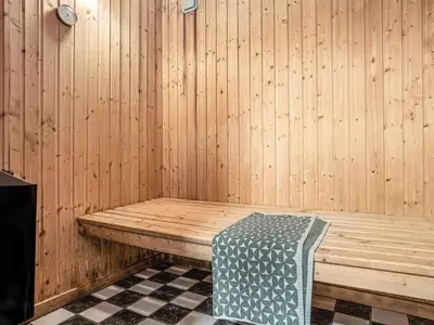 a sauna with a bench in a wooden wall at Holiday Home Caya - 750m from the sea by Interhome in Løkken