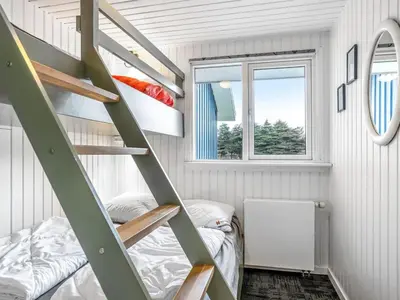 a room with a bunk bed and a ladder at Holiday Home Caya - 750m from the sea by Interhome in Løkken