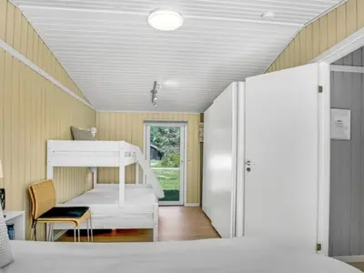 a room with a bunk bed and a desk at Holiday Home Quiana - 2km from the sea by Interhome in Pandrup