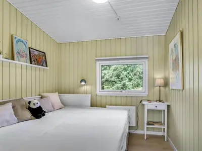a bedroom with a white bed and a window at Holiday Home Quiana - 2km from the sea by Interhome in Pandrup
