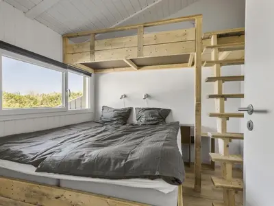 a bedroom with a bunk bed and a ladder at Holiday Home Erma - 125m from the sea by Interhome in Saltum