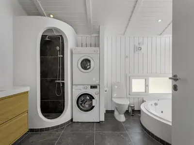 a bathroom with a washing machine and a toilet at Holiday Home Erma - 125m from the sea by Interhome in Saltum