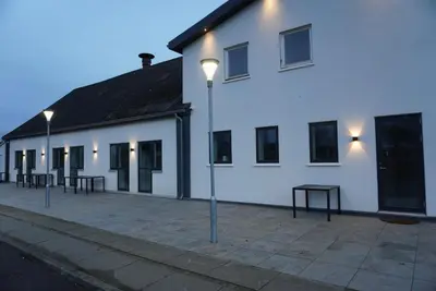 a white building with street lights in front of it at Birkelse Hotel og Kro in Birkelse