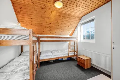 a bedroom with two bunk beds and a wooden ceiling at Family-Friendly Holiday Home With Pool, Located Close To The North Sea In Vrist in Harboør