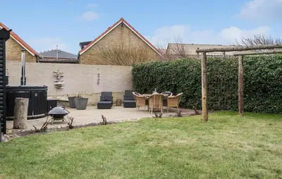 a patio with a table and chairs in a yard at Cozy Home In Thyborøn With Wifi in Thyborøn