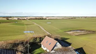 an aerial view of a house and a golf course at Jørgen's Feriehus in Lemvig