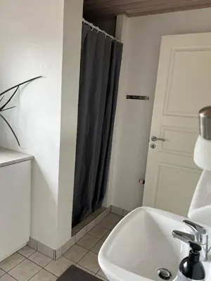 a bathroom with a sink and a shower curtain at Dejlig og hyggelig hus i Thyborøn in Thyborøn