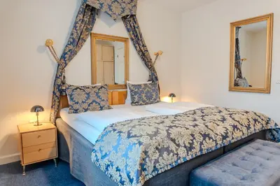 a bedroom with a four poster bed with a mirror at Hotel Palads Apartments in Viborg
