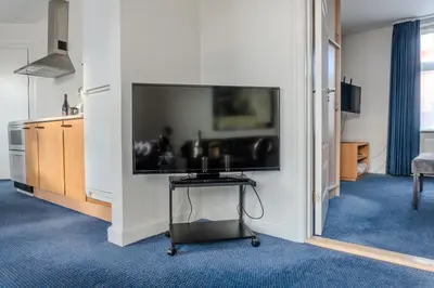a living room with a large flat screen tv on a wall at Hotel Palads Apartments in Viborg