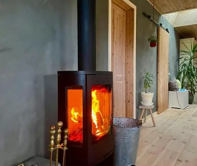 a stove with a fire inside of a room at Vesterhavsluft Og Natur Ved Nationalpark Thy in Thisted