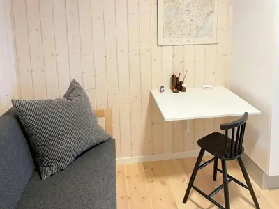 a room with a bed and a table and a chair at Stunning Sunrises Over Harre Vig in Roslev