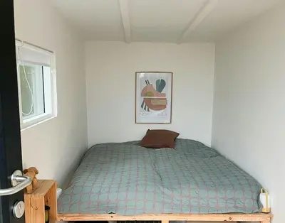 a bedroom with a bed with a blue comforter at Nature-Rich Oasis With Views Over The Limfjord in Roslev