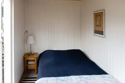 a bedroom with a bed and a lamp on a table at Authentic Family Summer House At The Limfjord in Roslev