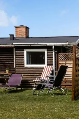 two chairs and a table in front of a cabin at Authentic Family Summer House At The Limfjord in Roslev