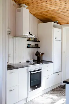 a kitchen with white appliances and a wooden ceiling at Authentic Family Summer House At The Limfjord in Roslev
